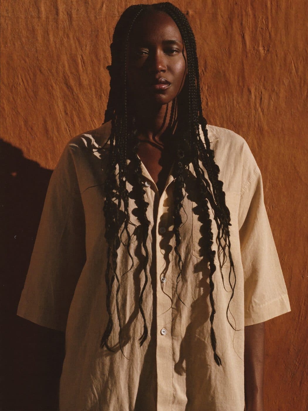 Mannequin en boho braids devant un mur ocre